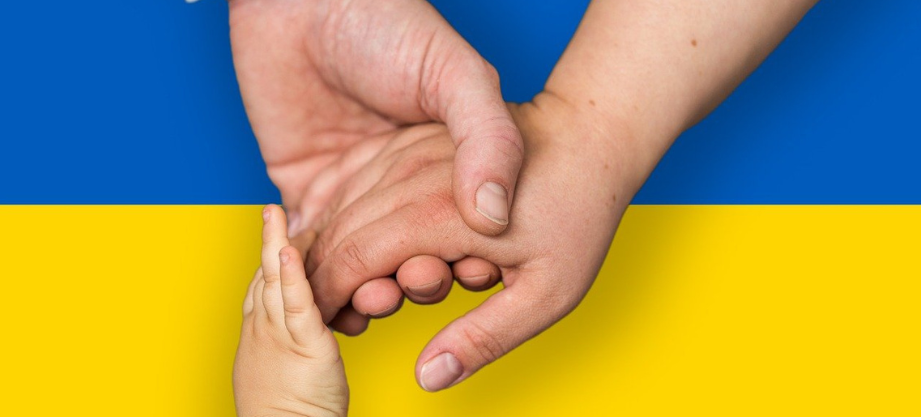 Ģimene tur rokas priekšā Ukrainas karogam