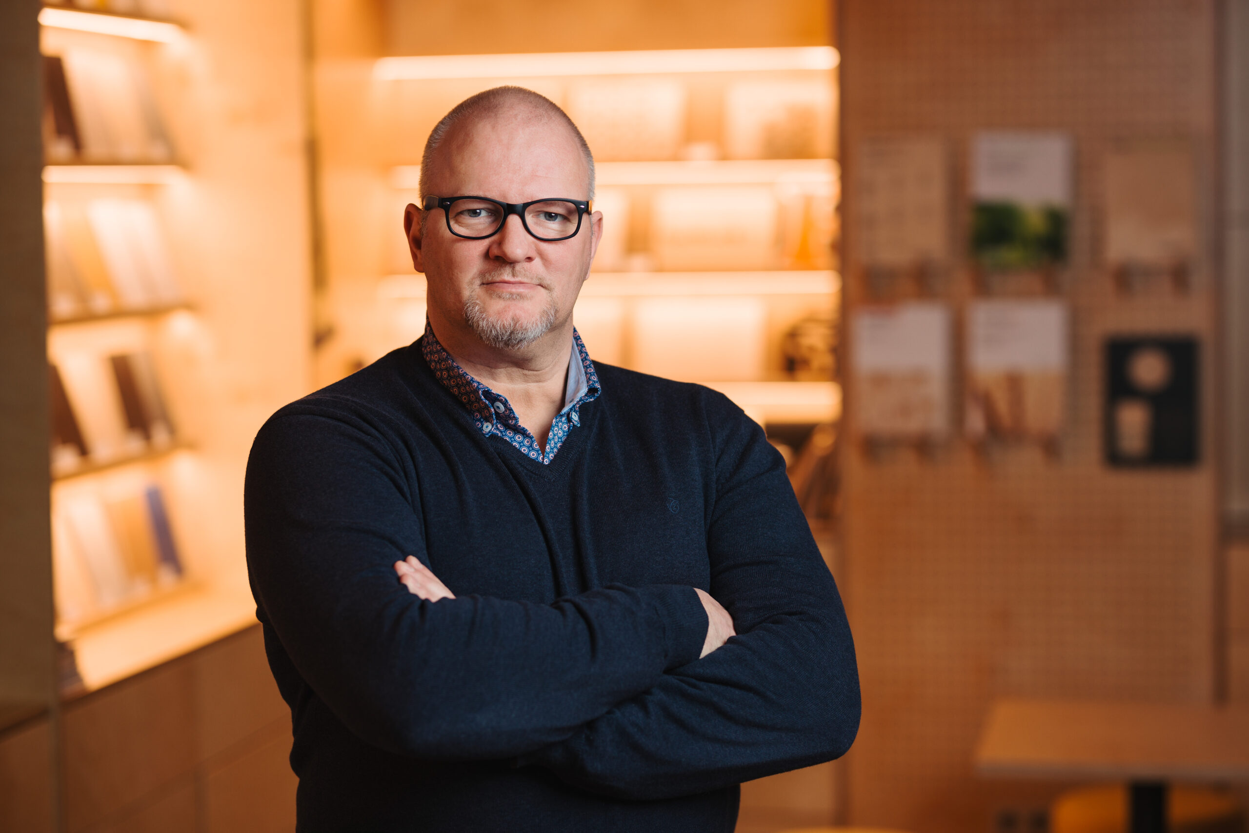 A man standing in front of a shelf full of plywood samples