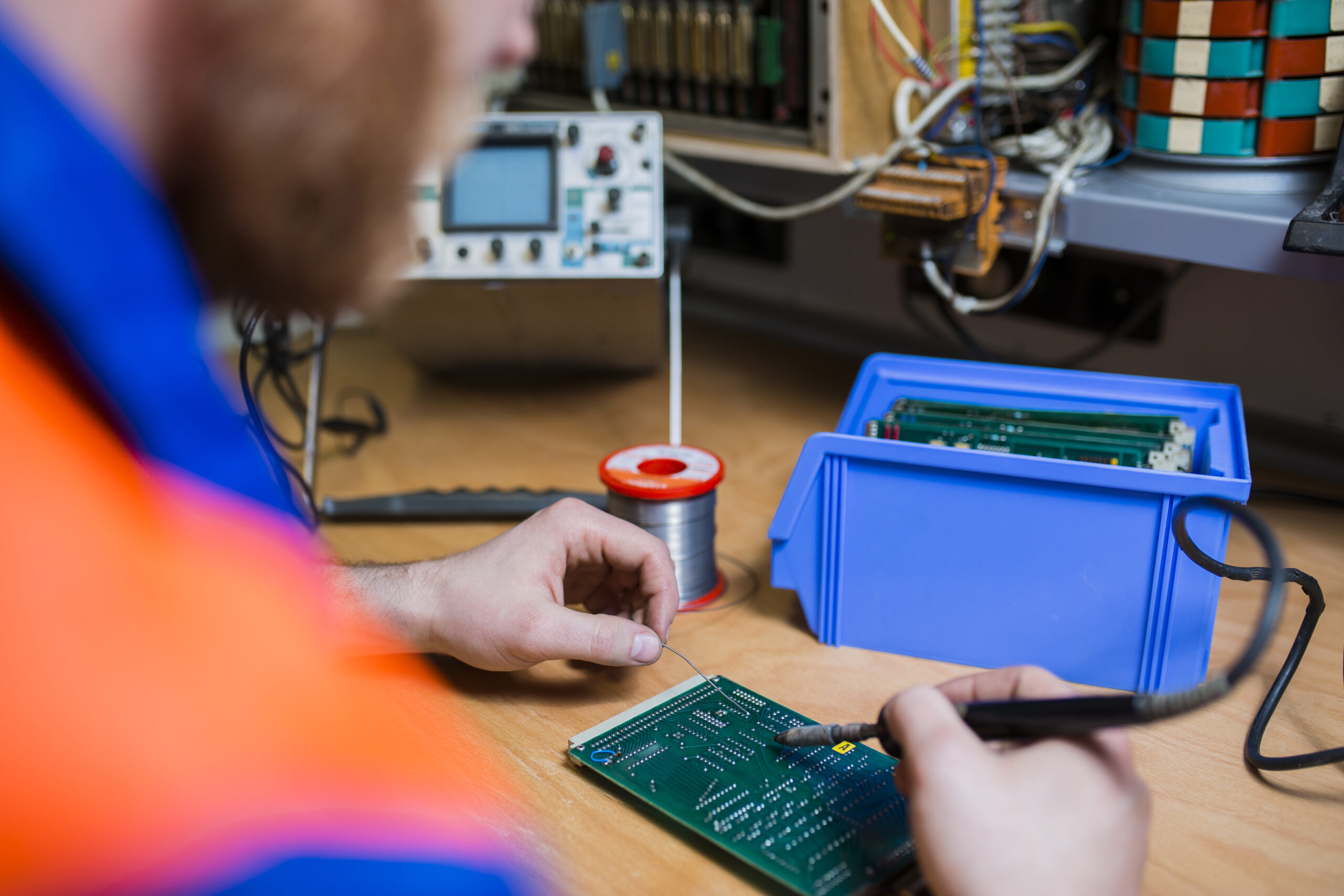 Elektriķis strādā pie elektroniskās iespiedshēmas plates