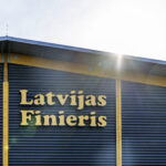 "Latvijas Finieris" logo on the front of a modern warehouse with wooden elements